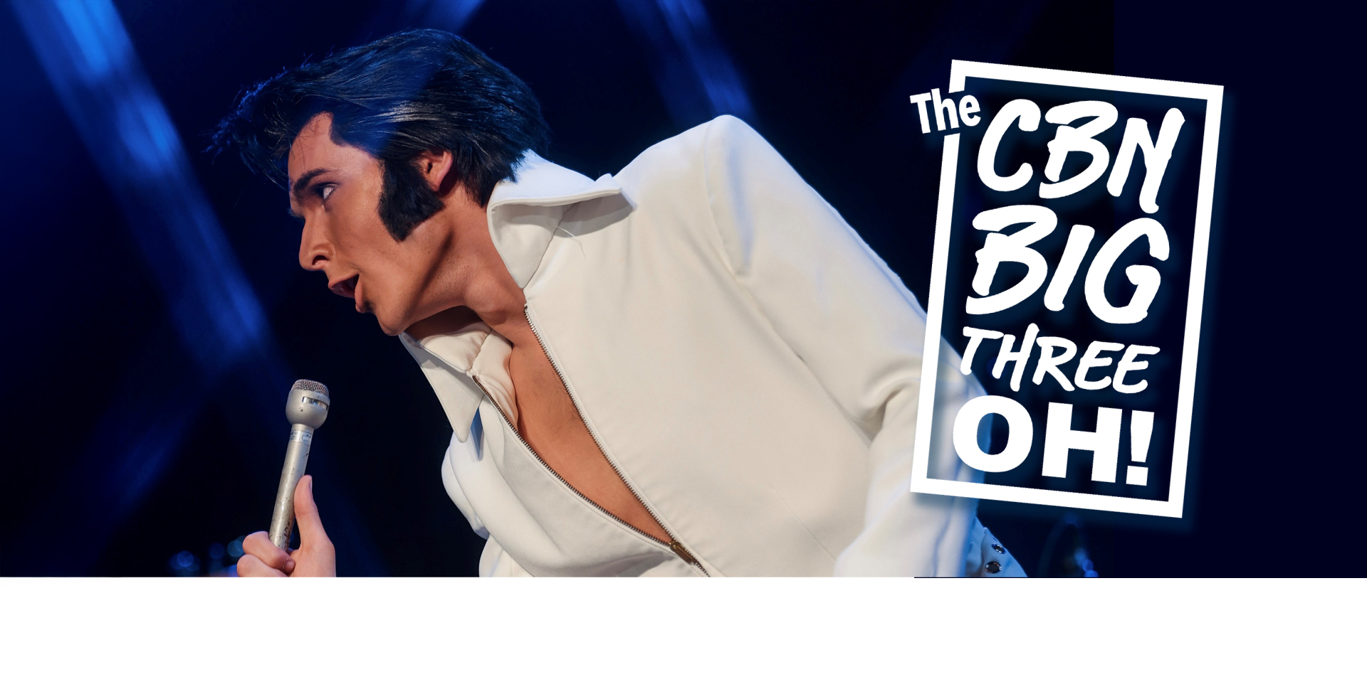 Elvis impersonator Matt Stone performing on stage wearing the iconic Elvis white jumpsuit.ite 