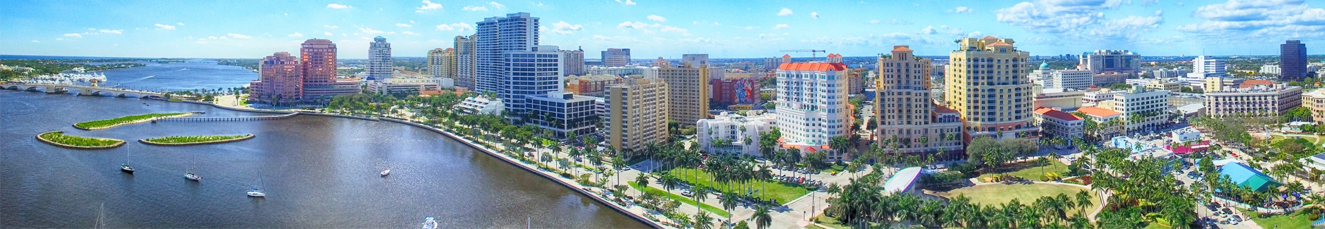 Panorama of West Palm Beach skyline along Intracoastal Waterway on a sunny day.