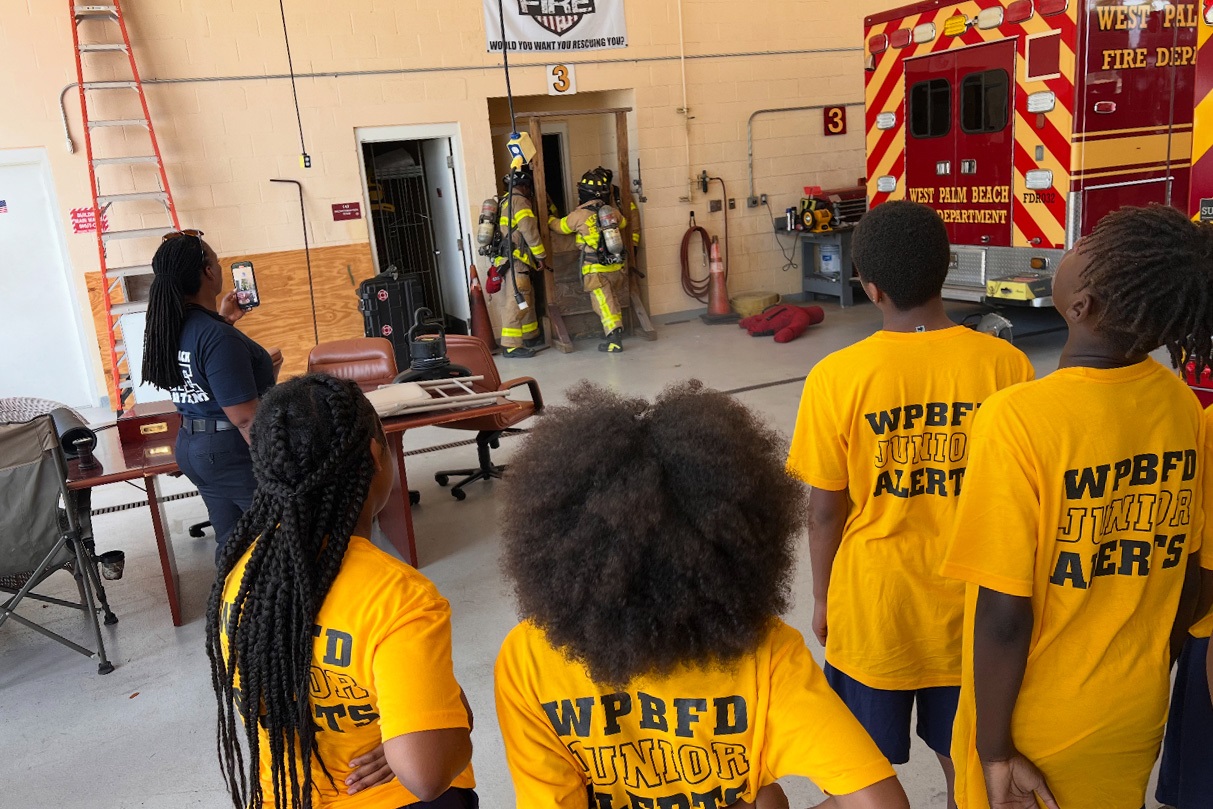 Firefighters attach a structure as Junior Alert members watch and learn