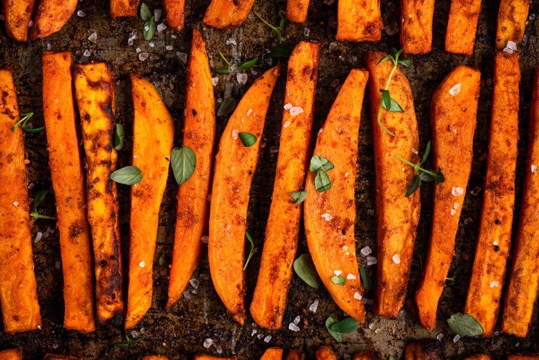 Homemade sweet potato fries baked in the oven, sprinkled with salt and herbs