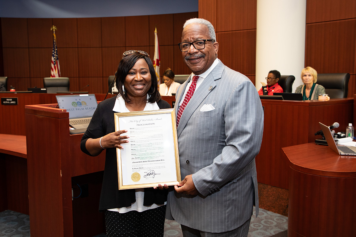 Telecommunicator Manager Suzette Dodd accepts the proclamation from Mayor Keith A. James
