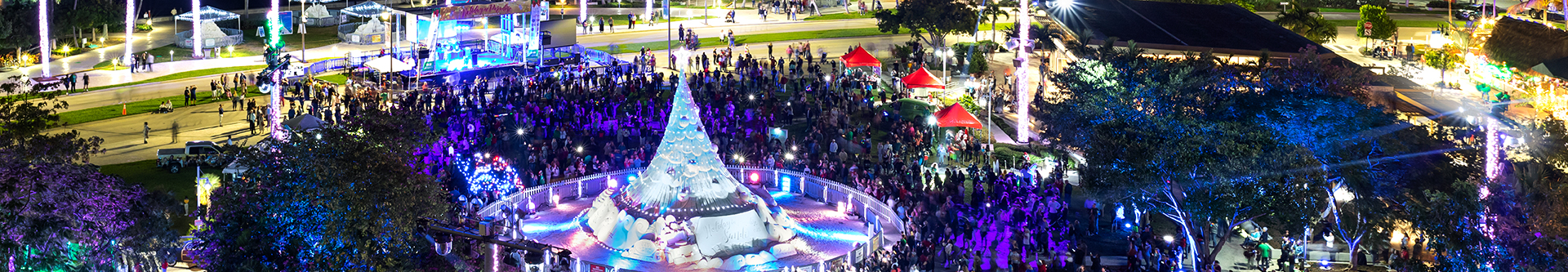 Pano aerial photo of the Sandi, holiday sand tree, lit up in blues on the West Palm Beach Waterfront.