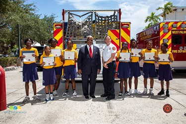 Eight Junior Alert Graduates are joined by West Palm Beach Fire Chief Diana Matty and Mayor Keith A. James