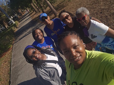 Individuals-smile-for-a-photo-along-the-sidewalk-on-Clear-Lake-Trail