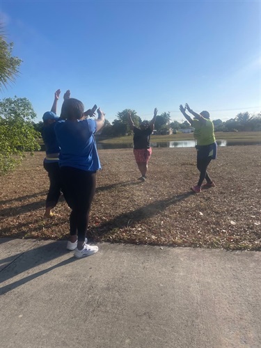 Individuals-with-arms-outstretched-overhead-during-walking-warmup