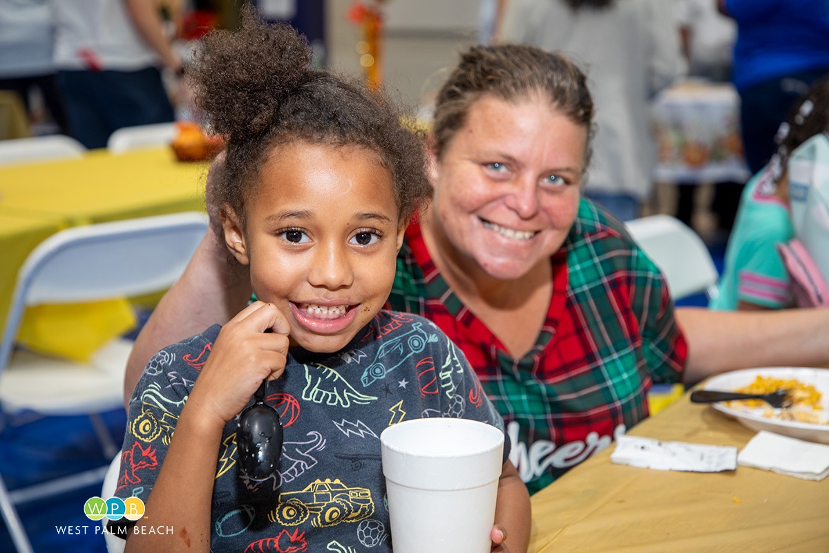 Child-with-beaming-smile-as-mom-looks-on-a.jpg