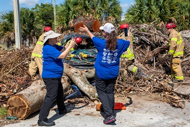 Citizen journalist actors get in the way of firefighters trying to clear debris and inspect a car buried in the rubble