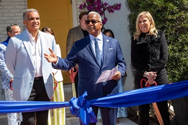 Three people standing behind a ribbon, Mayor Keith A. James, center, thanks the Boys and Girls Clubs for helping the youth of the City