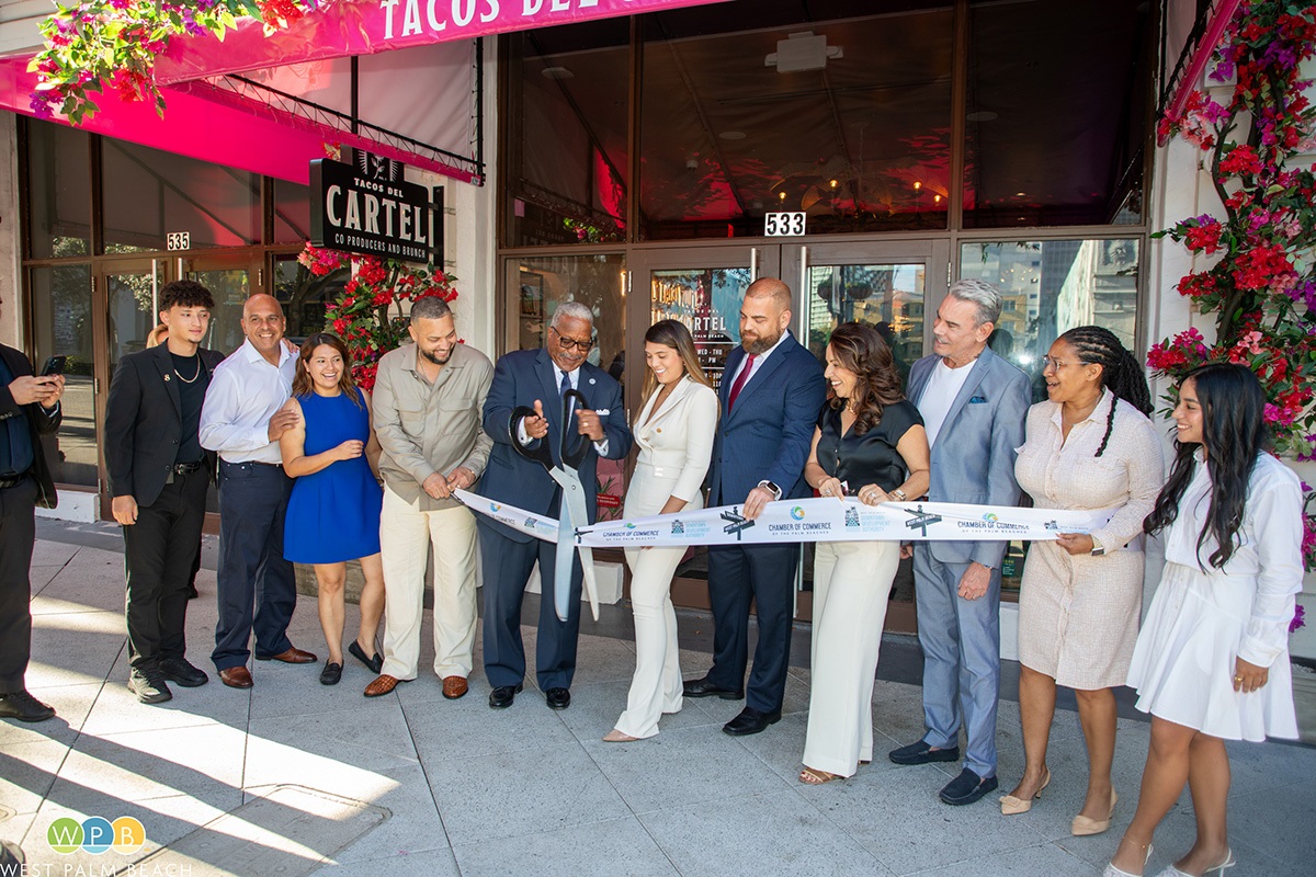 11 people lined up as Mayor Keith A. James cuts ribbon at Tacos del Cartel