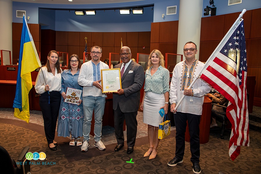 Six people standing, two holding flags