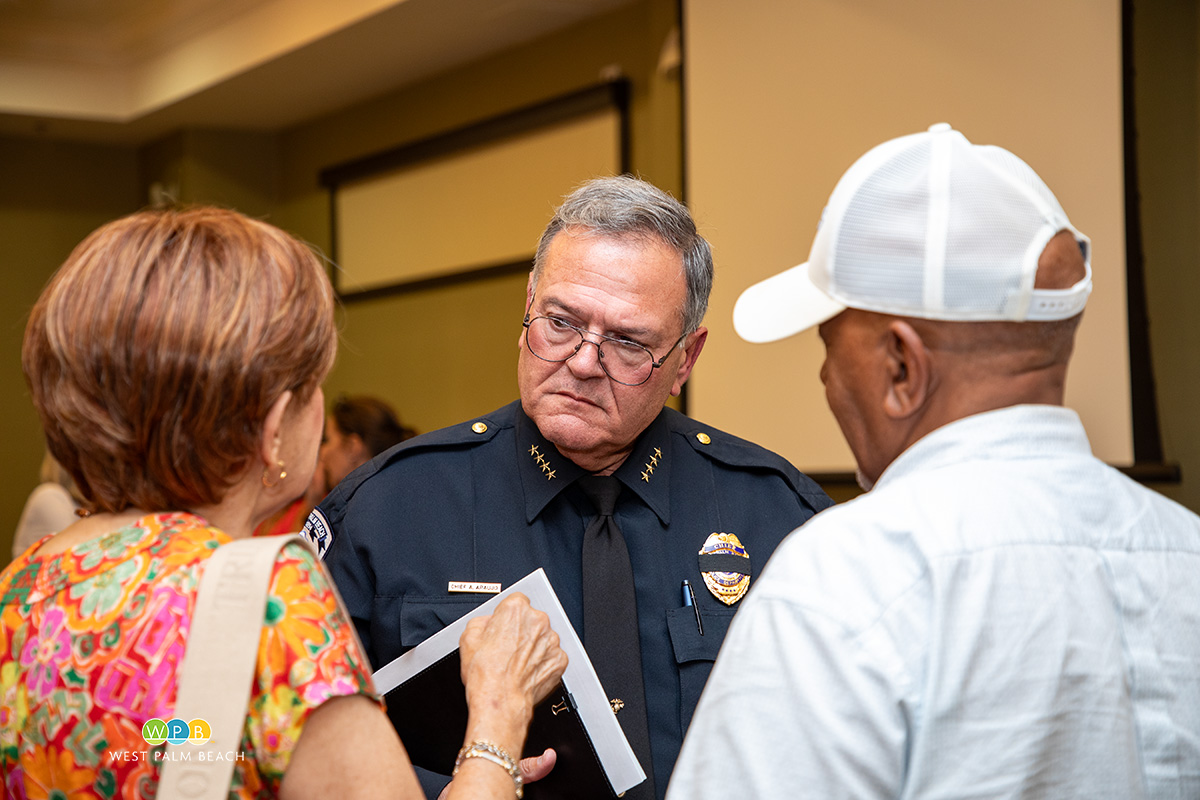 Three people, Police Chief Tony Araujo, middle, speaks with a man and woman