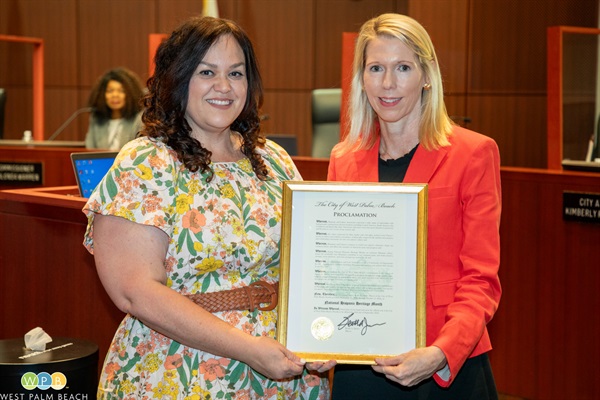 Susy Diaz is presented a proclamation by Commissioner Christy Fox