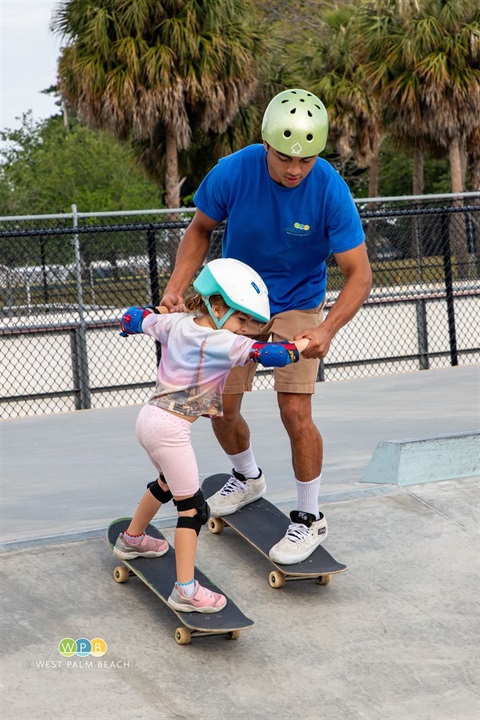 Phipps-Park-Skate-Park-counselor-helps-youngster-learn.jpg